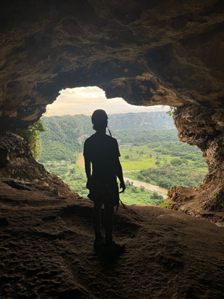 a man that is standing in the dirt with a mountain in the background