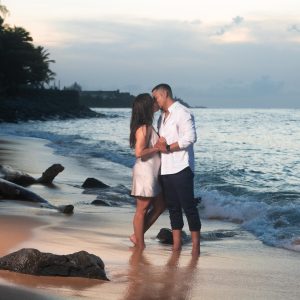 Couple embracing on a beach at sunset.