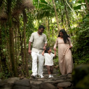 Family walking hand in hand in lush green forest.
